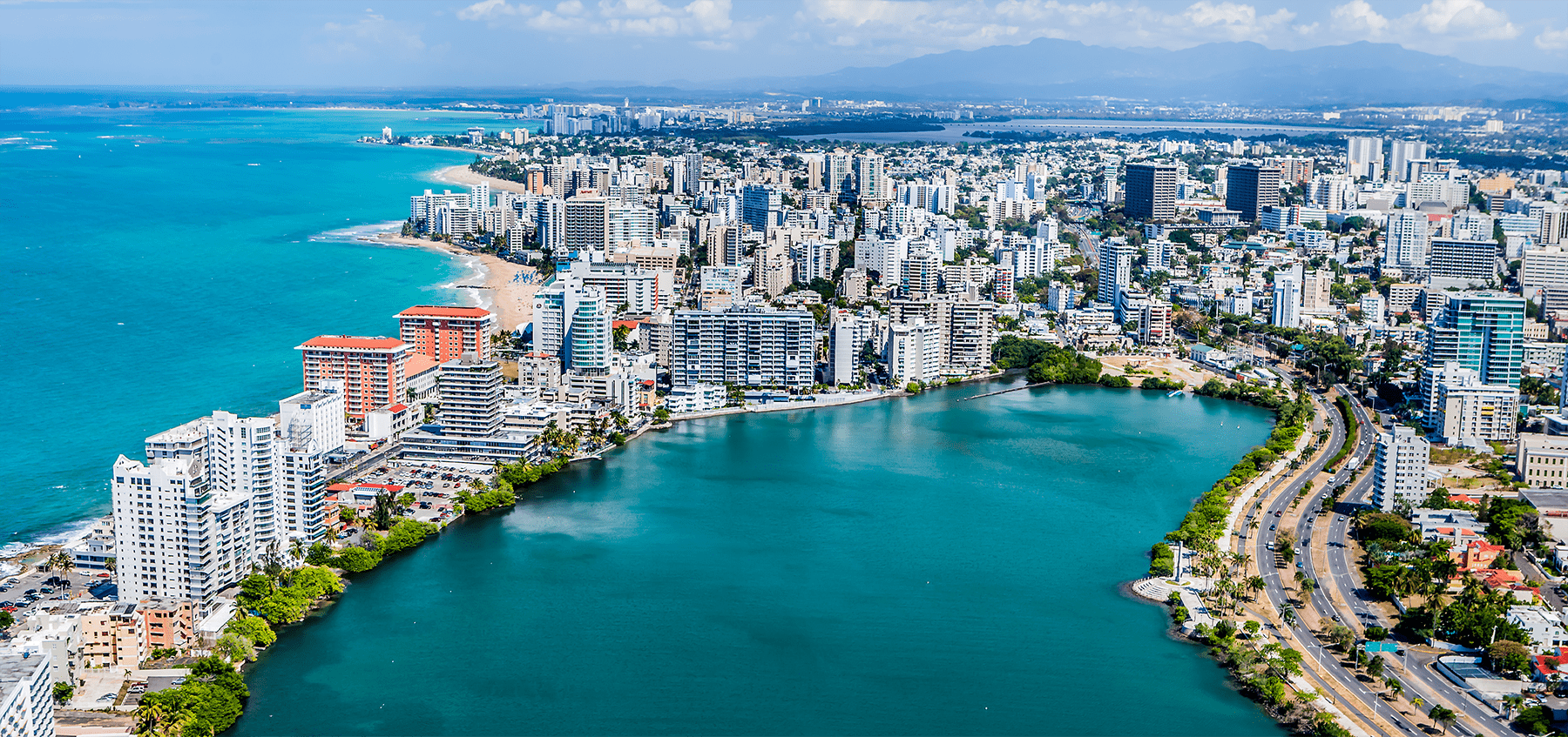 Aerial view over Condado, Laguna del Condado, and San Juan's coastal skyline.